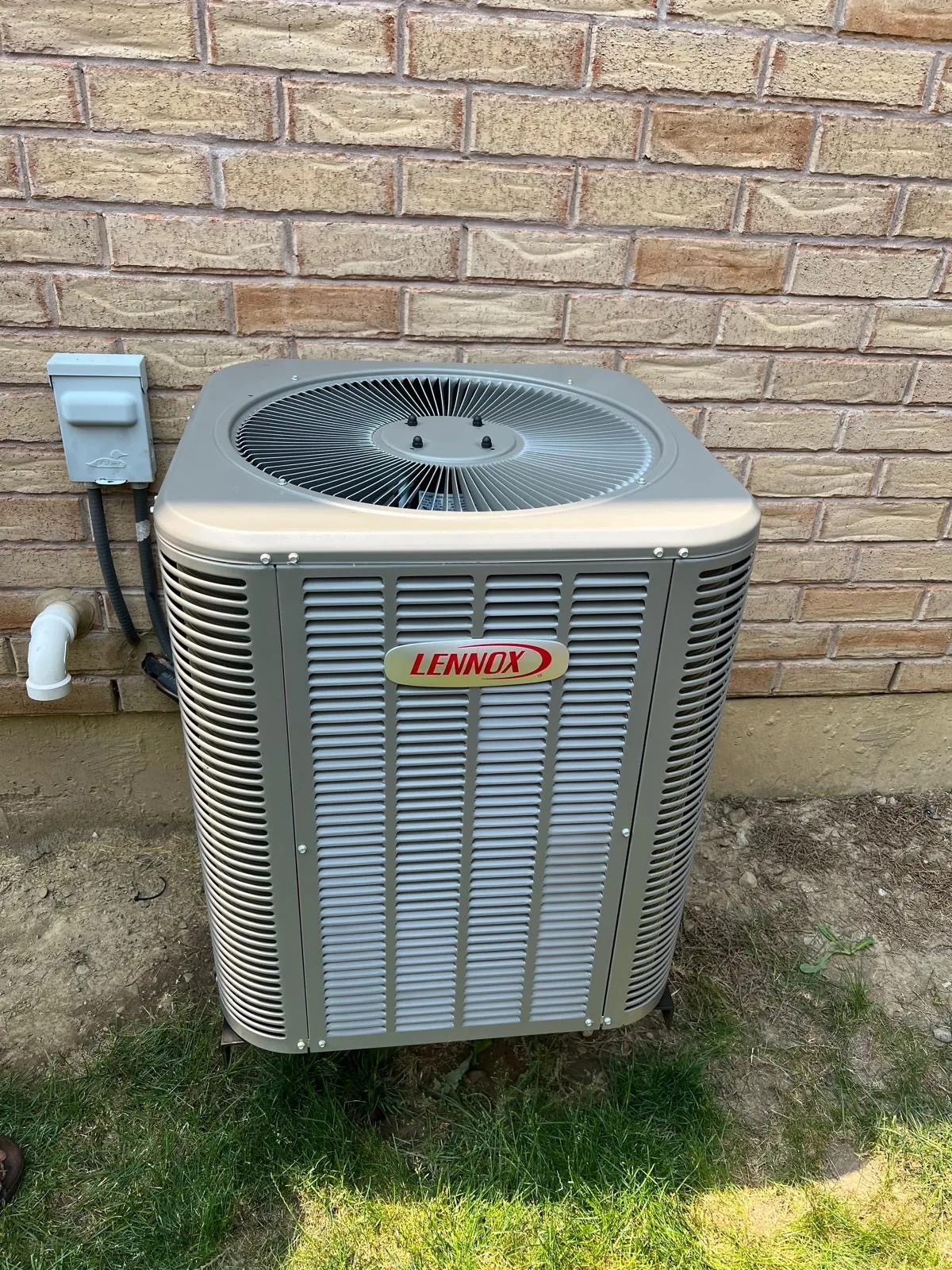 Outdoor central air conditioner condenser on a GTA home lawn after install