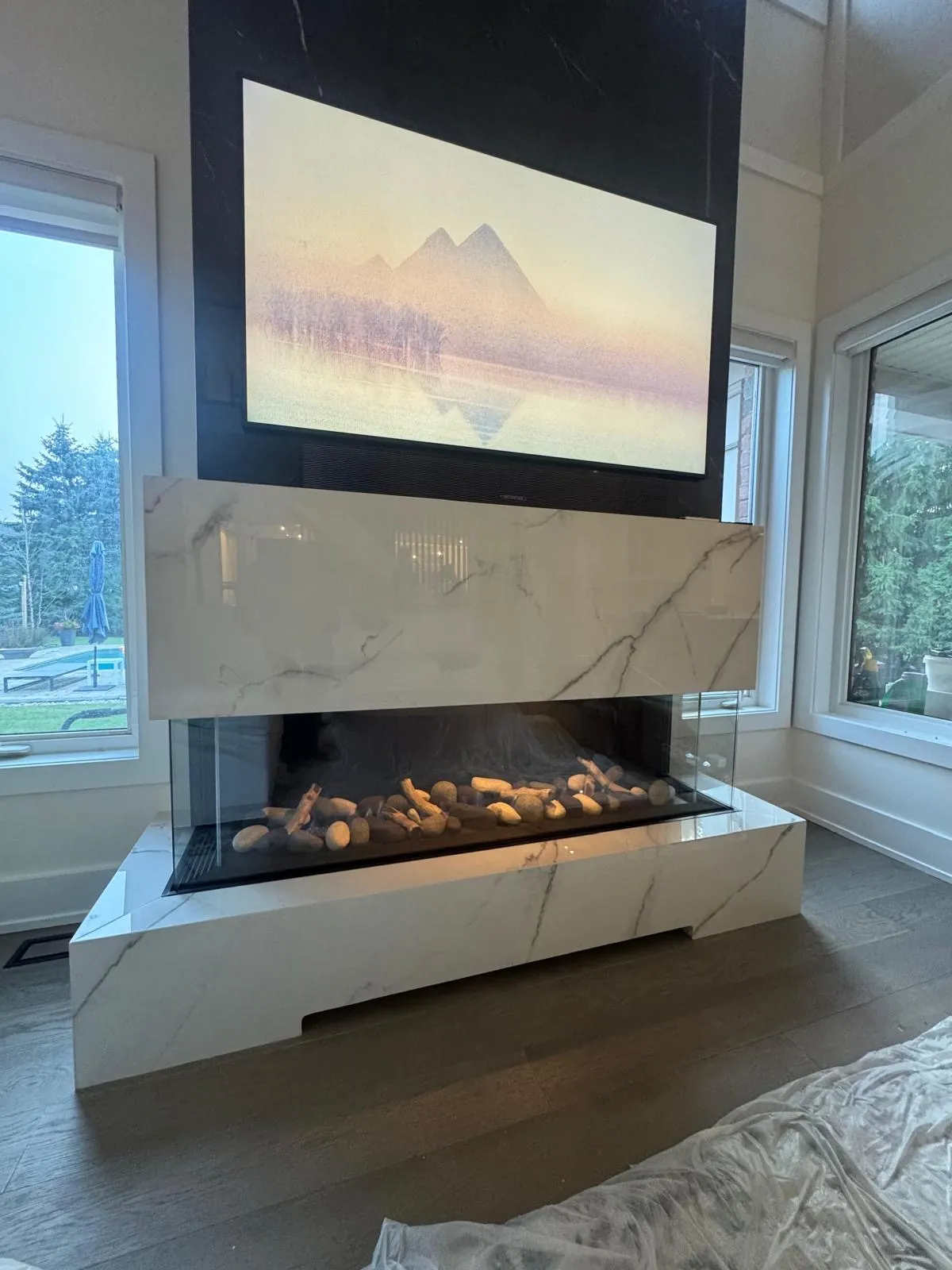 Premium marble linear gas fireplace beneath a wall-mounted TV — Delson Air install in the GTA