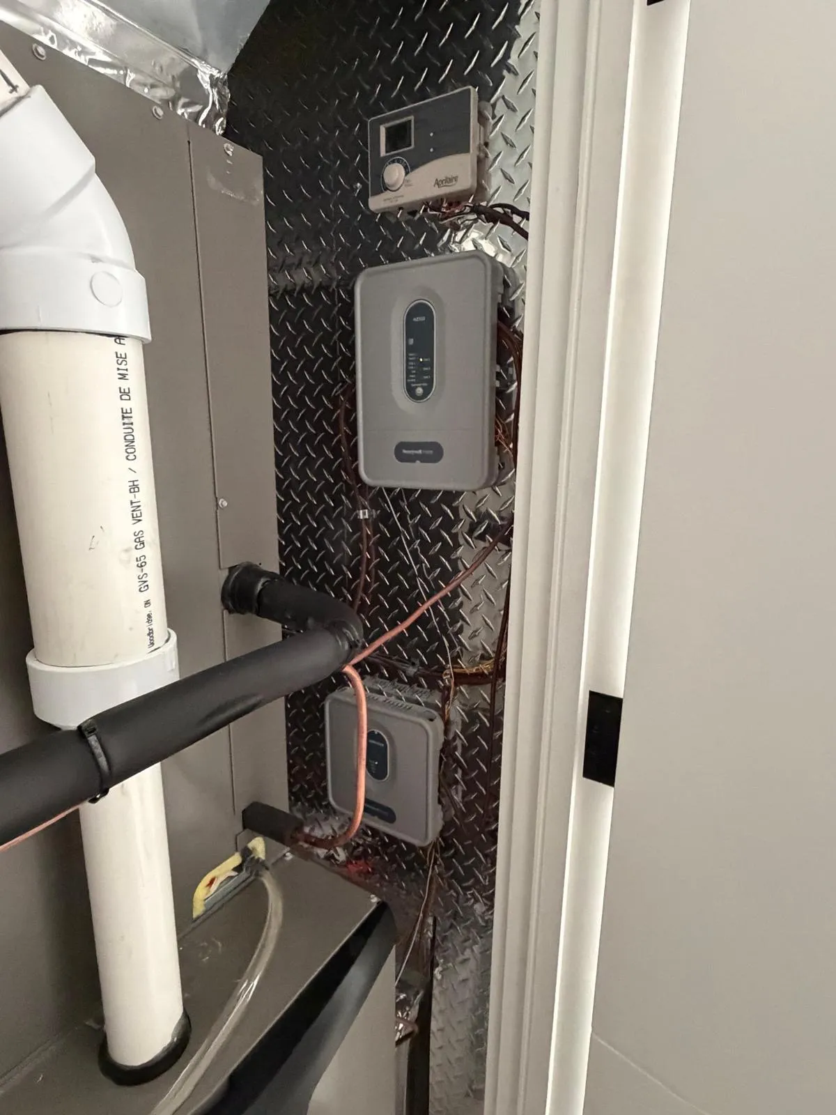 Wall-mounted gas tankless water heater installed in a GTA home utility room by Delson Air
